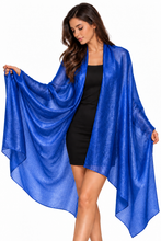 Load image into Gallery viewer, A woman modeling a sheer, flowing royal blue wrap or shawl over a black dress against a plain white background.