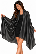Load image into Gallery viewer, A woman modeling a black satin-like shawl or wrap draped over her shoulders, worn over a black dress, against a plain white background.