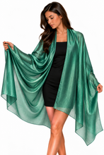 Load image into Gallery viewer, A woman modeling a sheer, metallic emerald green shawl draped over a black dress against a plain white background.