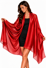 Load image into Gallery viewer, A woman modeling a flowing, semi-sheer red shawl or wrap over a black dress, set against a plain white background.