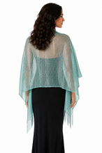 Load image into Gallery viewer, A woman shown from the back wearing a sheer, shimmering mint green wrap or poncho draped over a black dress, against a plain white background.