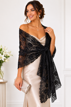 Load image into Gallery viewer, A woman models a black lace shawl draped over her shoulders, styled over a champagne satin dress and paired with a silver clutch in a bright indoor setting.