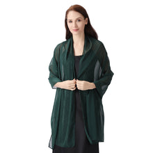 Load image into Gallery viewer, A woman modeling a dark green sheer shawl or lightweight cardigan draped over her shoulders, worn over a black dress, against a solid white background.