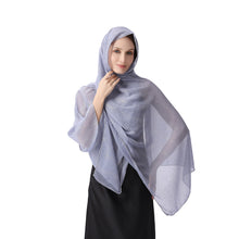 Load image into Gallery viewer, A woman modeling a sheer, light periwinkle blue hijab with subtle dotted patterns, paired with a black abaya, against a solid white background.