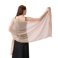 Load image into Gallery viewer, A woman shown from the back wearing a sheer beige shawl draped over her shoulders, holding it out wide against a plain white background.