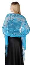 Load image into Gallery viewer, A woman shown from the back wearing a light blue sheer embroidered shawl with floral patterns and fringe over a black dress, against a plain white background.