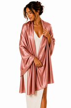 Load image into Gallery viewer, A woman wearing a shiny, satin-like dusky pink pashmina over a white dress, photographed against a plain white studio background.