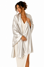 Load image into Gallery viewer, A woman modeling a shiny silver satin pashmina over a cream-colored dress against a plain white background.