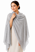Load image into Gallery viewer, A woman modeling a lightweight, semi-sheer light gray shawl wrap draped over her shoulders, paired with a cream-colored dress against a solid white background.